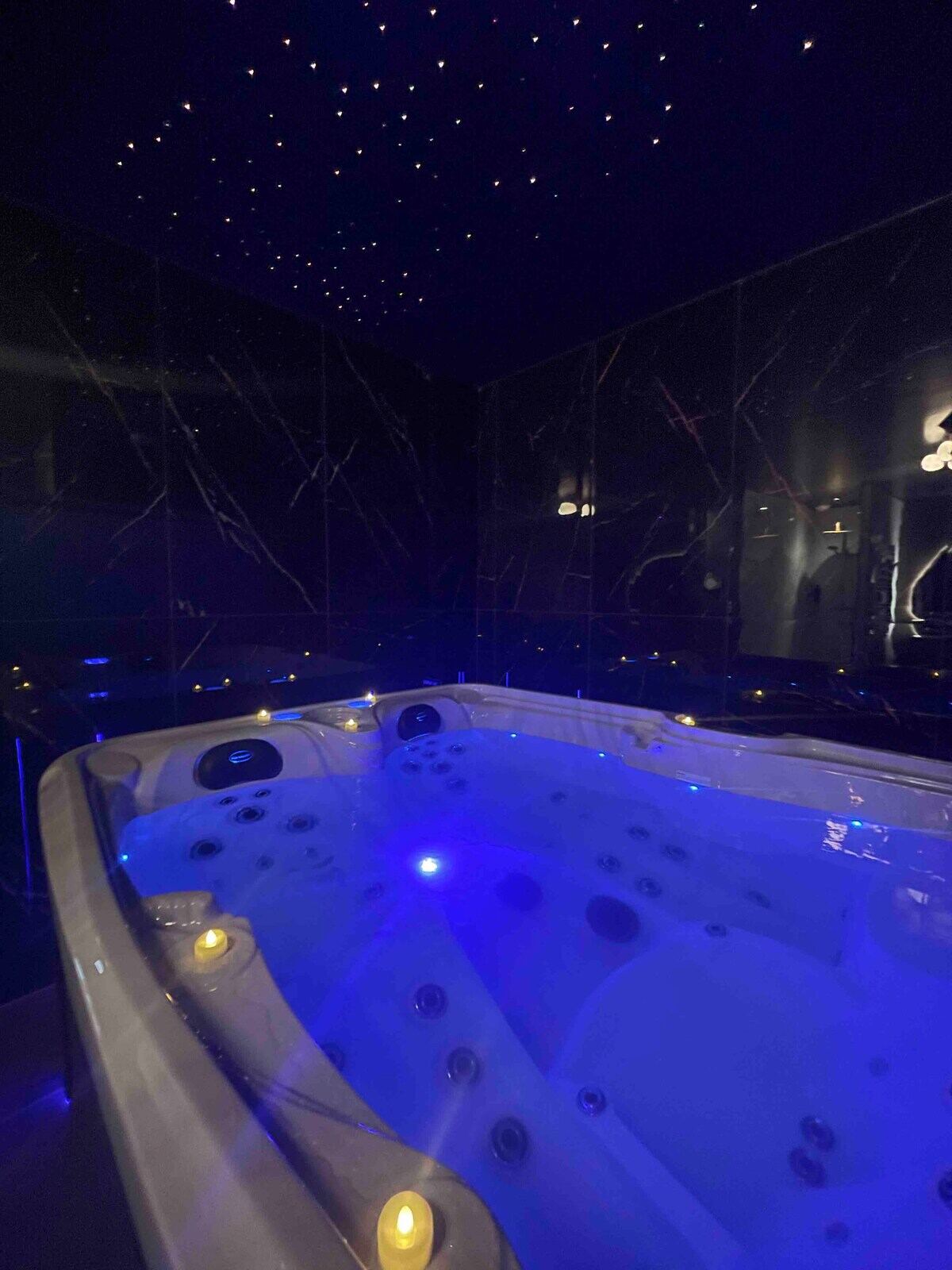 Spa aux lumières bleues sous un plafond étoilé