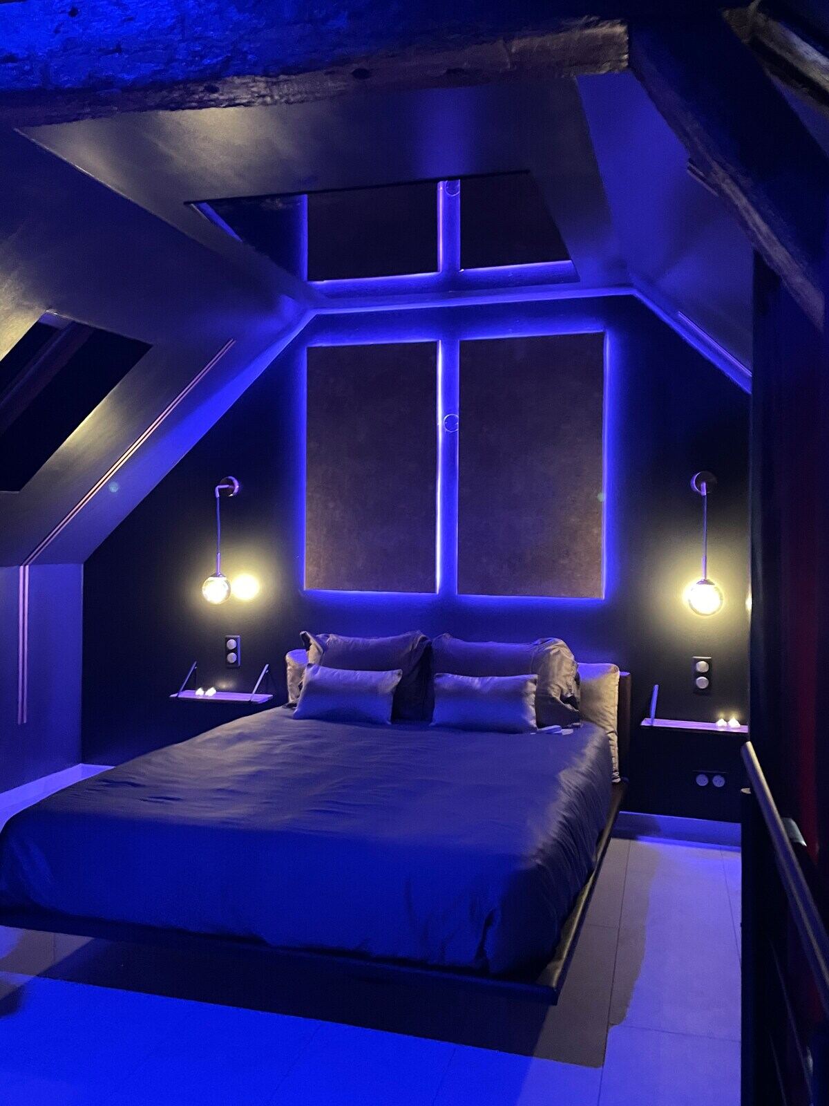 Lit queen size baigné d'une lumière bleue